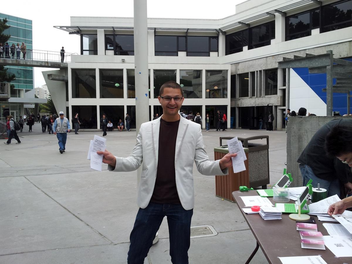A staff holding flyers to promote the free and open source software event